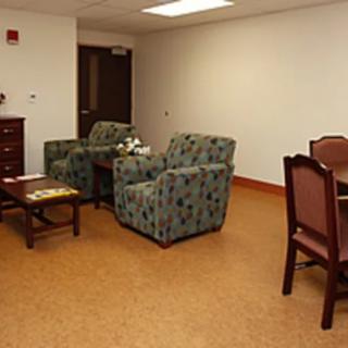 A waiting room with comfortable seating and a small table.