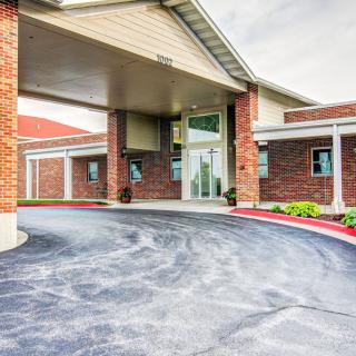 A brick building entrance with a covered driveway.