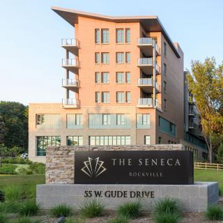 A modern residential building named 'The Seneca' located at 55 W. Gilman Drive, featuring contemporary architecture.