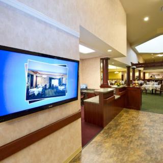 A modern lobby with a television screen and open reception area.