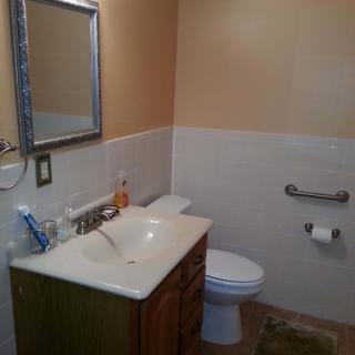 A clean and well-organized bathroom with a sink, mirror, and toilet.