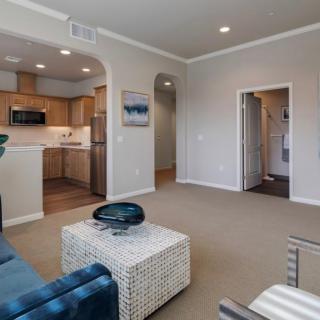 A modern living space featuring an open floor plan with a view of the kitchen.