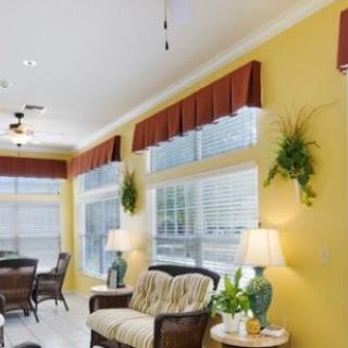 A bright living room with yellow walls, comfortable seating, and decorative indoor plants.