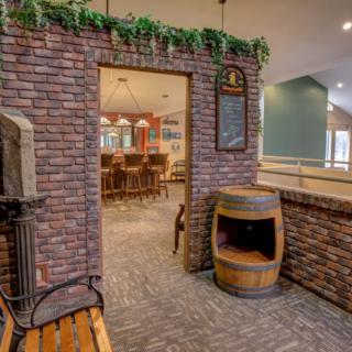 Cozy indoor restaurant with a brick entrance and decorative wine barrel.