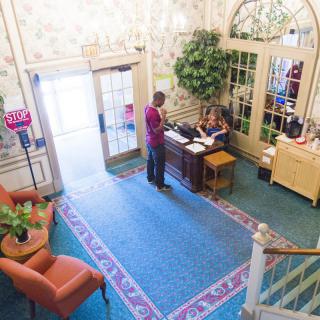 A hotel lobby with a reception desk and guests checking in.