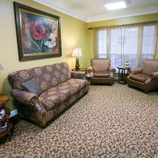 A cozy living room with a sofa, armchairs, and decorative elements.