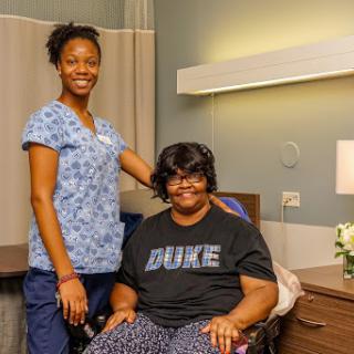 A nurse standing beside a patient in a hospital room, showcasing compassion and care.