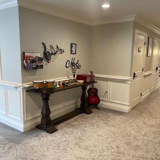 A neatly decorated hallway featuring a console table, wall art, and a guitar.