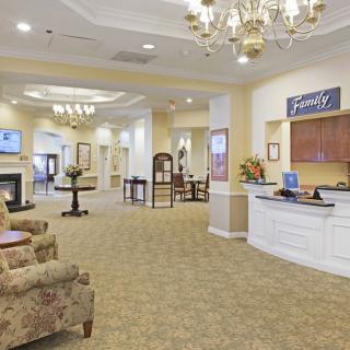A spacious and elegantly decorated hotel lobby with a reception desk and chandelier.
