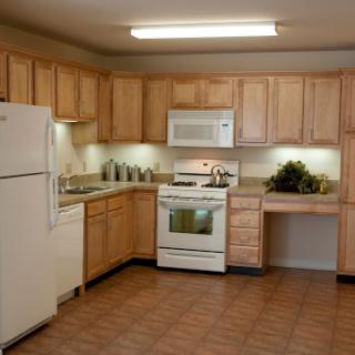 A modern kitchen featuring wooden cabinets and essential appliances.