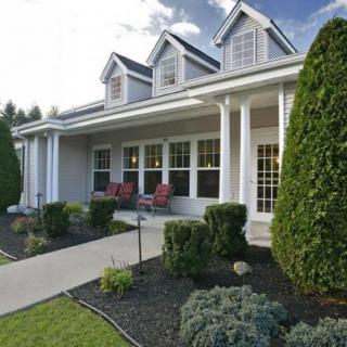 A charming house with a welcoming front porch and well-maintained landscaping.