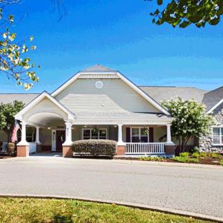 A suburban residential house with a large driveway and well-maintained landscaping.