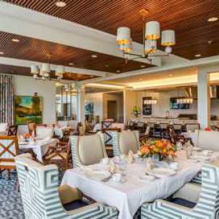 A beautifully designed restaurant interior with elegantly set tables and comfortable seating.