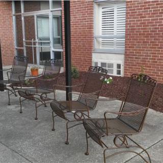 Outdoor patio seating area with metal chairs arranged on a concrete surface.