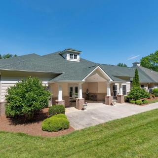 A well-maintained residential house with a landscaped lawn and clear blue sky.