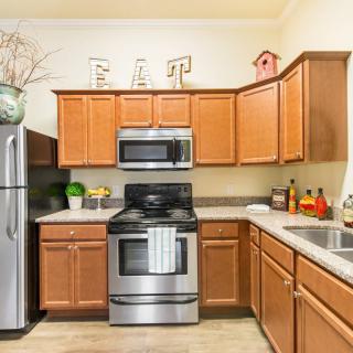 A modern kitchen featuring stainless steel appliances and wood cabinetry.