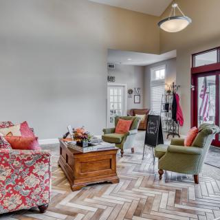 A cozy living room featuring vibrant decor and a herringbone-patterned floor.