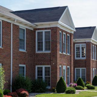 A suburban residential brick building with manicured landscaping.