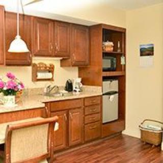 A cozy kitchen interior with wooden cabinets, appliances, and decorative elements.
