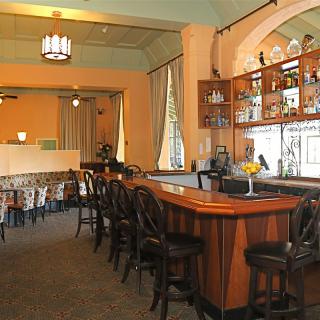 A cozy bar and restaurant interior with a wooden counter and seating area.