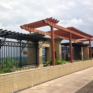 A modern outdoor structure featuring decorative pergolas and lush greenery.