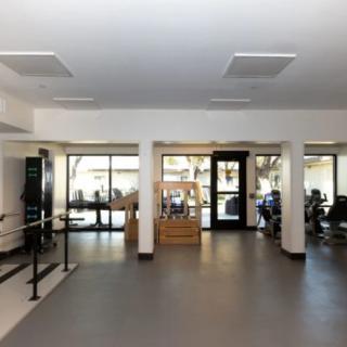 A spacious gym with various exercise equipment and a bright, open layout.