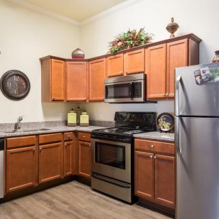 A modern kitchen featuring wooden cabinets and stainless steel appliances.