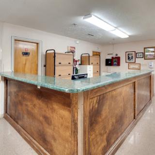 A view of a reception area with a wooden counter and office furniture in the background.