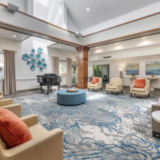 A spacious, bright lobby with comfortable seating and a grand piano.