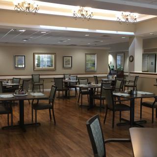 An empty restaurant dining area with neatly arranged tables and chairs.