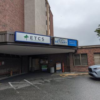 A healthcare facility with visible signage and a parking lot on an overcast day.