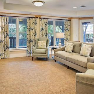 A cozy living room with a sofa, armchair, and patterned curtains creating a warm and inviting atmosphere.