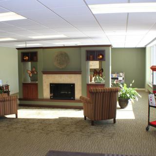 A cozy office waiting area with comfortable chairs and a fireplace.