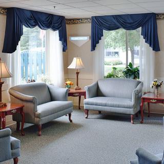 A cozy living room with sofas, elegant curtains, and warm lighting.