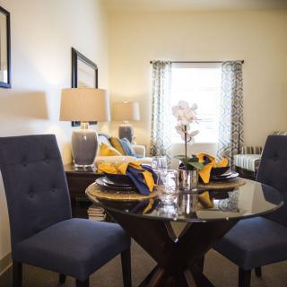 A stylish dining room with a set table and upholstered chairs.