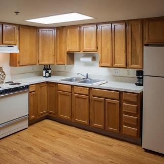 A modern kitchen with wooden cabinets and essential appliances.