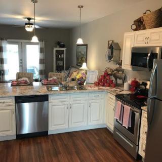 A modern kitchen with white cabinets and stainless steel appliances, featuring a cozy and inviting atmosphere.