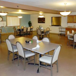 A modern dining area with multiple tables and chairs, well-lit and spacious.