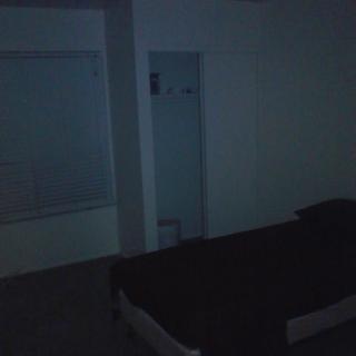 A dimly lit room with a bed and window.