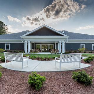 A beautifully designed building with landscaped gardens and benches, perfect for relaxation.