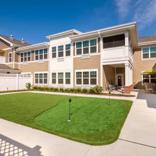 A residential building with a well-maintained lawn on a sunny day.
