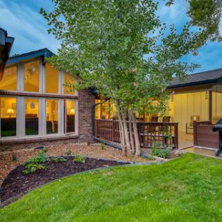 A charming house exterior showcasing beautiful landscaping and serene outdoor space at dusk.