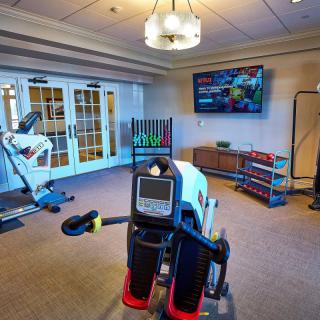 A cozy home gym with various exercise equipment and a TV for entertainment.