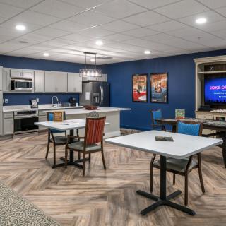 A modern kitchen and dining area with blue walls and herringbone flooring.