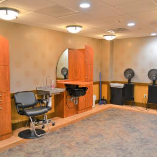 An interior view of a modern hair salon with styling stations and waiting areas.