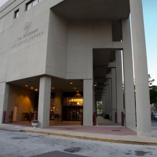 An exterior view of a modern building with an entrance located on a city street.