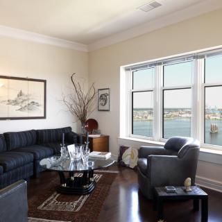 A modern living room with a large window offering a scenic view and comfortable seating arrangements.