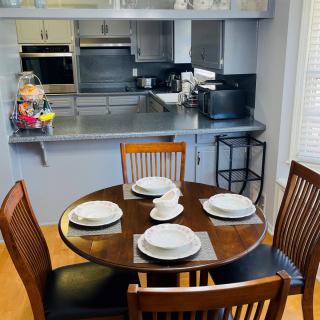A modern kitchen with a round dining table set for four.