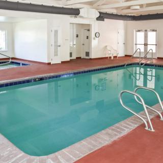 An indoor swimming pool area with clear water and surrounding lounge space.