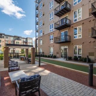 Modern apartment complex with outdoor seating and balconies.